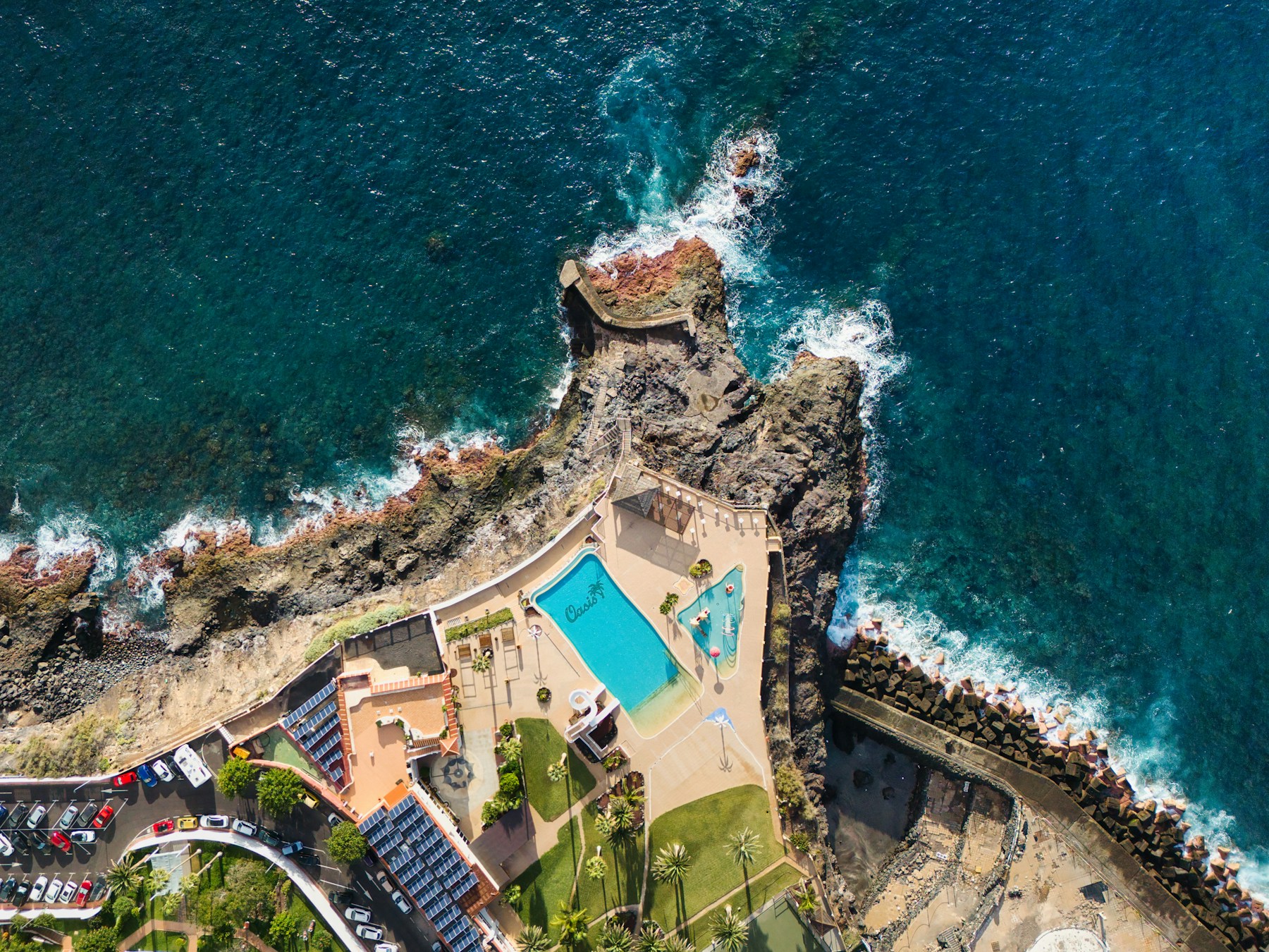A coastal resort with a turquoise pool and ocean views